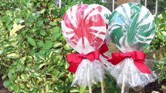 two lollipops wrapped in cellophane and tied with red ribbon are sitting on top of each other