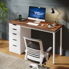 a desk with a computer on top of it and a chair in front of it