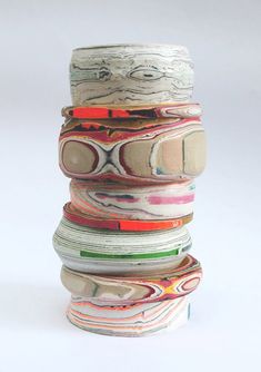 a stack of different colored objects sitting on top of each other in front of a white background