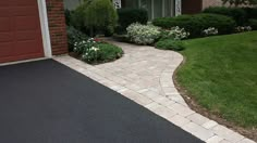 a brick driveway leading to a house