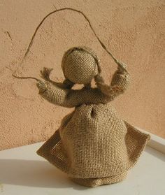 a small doll is sitting on a table with a string attached to it's head