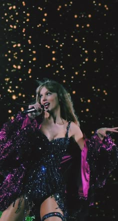 a woman in a black and purple dress on stage