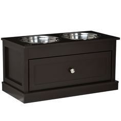 two bowls on top of a black cabinet with one drawer open and the other closed