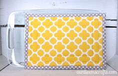 an oven mitt with yellow and gray circles on it, sitting on a counter