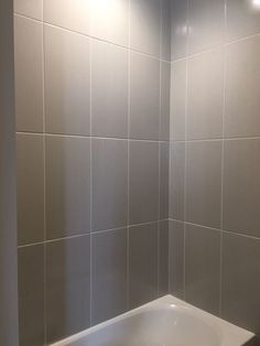 a white bath tub sitting inside of a bathroom next to a shower head mounted faucet