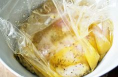 a white bowl filled with chicken wrapped in plastic