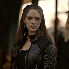 a woman with long hair wearing a leather jacket