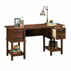 a wooden desk with two drawers and a lamp