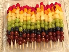 fruit skewers are arranged in the shape of a rainbow