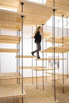 a woman is walking up some stairs made out of wood and metal chains with her legs in the air