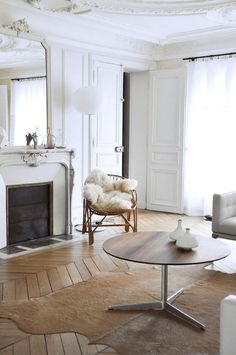 a living room filled with furniture and a fire place next to a white fireplace mantel