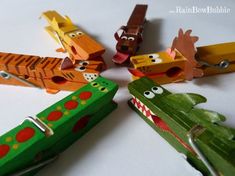 a group of wooden toy animals sitting on top of a white table next to each other