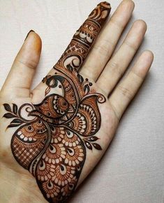 the hand is decorated with henna designs on it's palm, and has an intricate