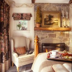 a living room filled with furniture and a fire place in front of a painting on the wall