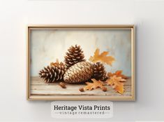 an oil painting of two pine cones and leaves on a wooden table with the words heritage vista prints above it