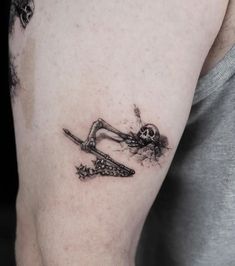 a skeleton holding a knife on the side of his arm with an ink splattered design