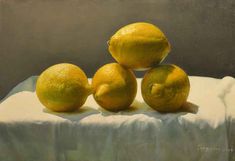 three lemons sitting on top of a white cloth