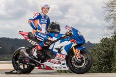 a man standing next to a racing motorcycle