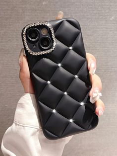 a woman holding a black cell phone case with diamonds on the front and bottom cover