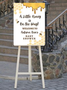 a sign that is on the sidewalk near some stairs and steps with honey dripping from it