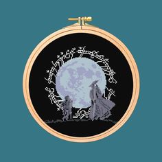 a cross stitch pattern with the image of two wolfs in front of a full moon