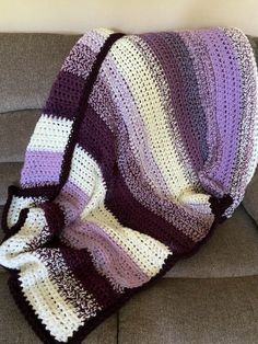 a crocheted blanket sitting on top of a couch