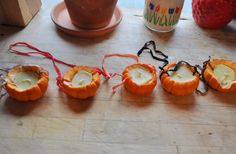 four small pumpkins sitting on top of a wooden table