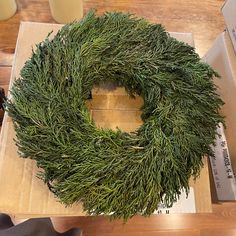 a green wreath sitting on top of a cardboard box