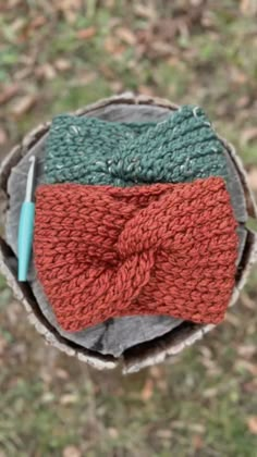 a knitted bow tie sitting on top of a piece of wood in the grass