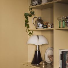 a lamp is sitting on top of a dresser next to a book shelf with books