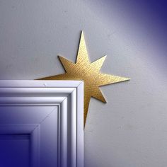 a gold star is on the wall next to a white door with a blue background