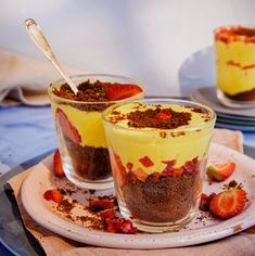 two desserts with strawberries in them on a plate