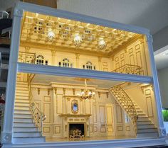 the inside of a doll house with stairs and chandeliers on it's walls