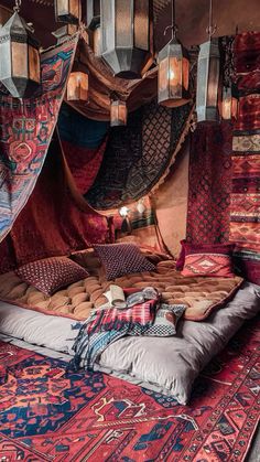 A bedroom adorned with rich Moroccan patterns and textures. A low-lying bed is draped in layers of colorful textiles, and intricate metal lanterns cast warm, flickering light. A vintage rug covers the floor, and handcrafted wooden furniture adds a rustic touch Beds Low To The Ground, Marrakech Style Decor, Low Frame Bed, Floor Bed Boho, Cave Bed, Arabic Furniture, Floor Meditation Space, Moroccan Bedroom Decor, Middle Eastern Bedroom Aesthetic