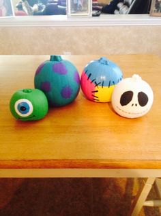 three brightly colored balls sitting on top of a wooden table