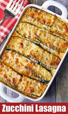 zucchini lasagna in a white casserole dish on a red and white checkered napkin