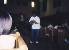 a man standing in front of some wooden pews