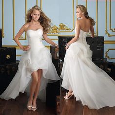 two beautiful women in wedding dresses standing next to each other with suitcases behind them