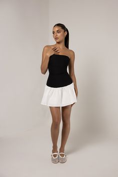 Introducing the Black Strapless Colorblock Flare Mini Dress, a chic and versatile piece that combines modern style with a playful silhouette. Featuring a sleek black strapless bodice that highlights the neckline and shoulders, the dress contrasts with a flared white skirt for a flattering colorblock design. The fitted top hugs the body, while the flared skirt adds movement and dimension, making it perfect for both casual and semi-formal occasions. Ideal for summer outings or evening events, this dress effortlessly balances elegance and fun. Summer Black Strapless Mini Dress, Chic Strapless Stretch Mini Dress, Chic Stretch Strapless Dress, Chic Stretch Strapless Cocktail Dress, Flirty Black Bandeau Mini Dress, Flirty Black Bandeau Strapless Dress, Black Off-shoulder Tube Top For Date Night, Chic Black Strapless Mini Dress, Chic Black Strapless Tube Top