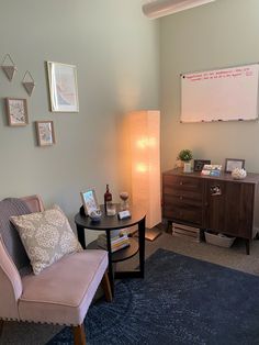 a living room with a couch, chair and television on the wall next to a dresser