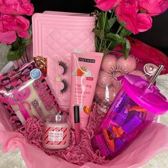 a pink basket filled with cosmetics and flowers