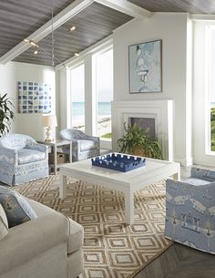 a living room with couches, chairs and a coffee table in front of a fireplace