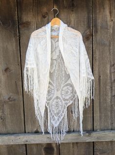 Lovely metallic silver lace piano shawl, 1980s vintage.  Perfect long drape & length, with luxurious fringe and woven Art Deco floral detailing.   An elegant accessory for a night out, or a Bohemian touch for your skinny jeans and cowboy boots. Very romantic, old-world, and timeless. Made in Japan 55% rayon, 30% nylon, 15% lurex roughly 73 inches at it's widest (not counting fringe) roughly 51 inches at it's longest (not counting fringe) fringe roughly 7 inches long Some general fabric wear, inc Bohemian Spring Wrap Scarves, Spring Bohemian Shawl Scarf, Bohemian Fringe Shawl For Festivals, Bohemian Spring Shawl, One Size Lace Shawl, Summer Shawl With Tassels, Bohemian Crochet Lace Shawl For Spring, Spring Shawl With Lace Trim, Bohemian Fringe Shawl For Spring