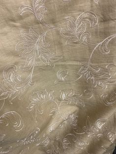 an embroidered fabric with white flowers on it