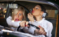 two women sitting in a car talking on the phone