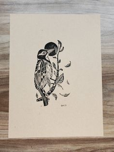 a black and white drawing of a bird perched on a branch with leaves around it