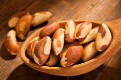 a wooden spoon filled with nuts on top of a table