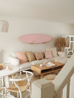 a living room filled with furniture and a surfboard mounted to the wall above it