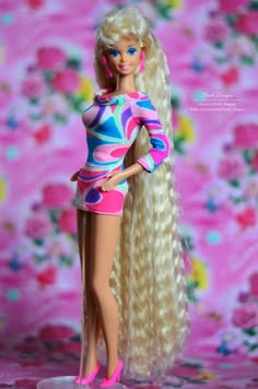 a barbie doll with long blonde hair and bright pink shoes standing in front of a floral background