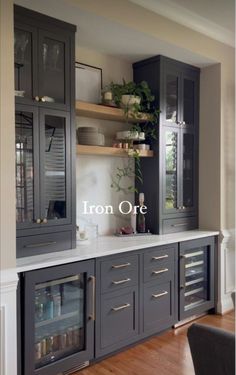 a kitchen with gray cabinets and white counter tops